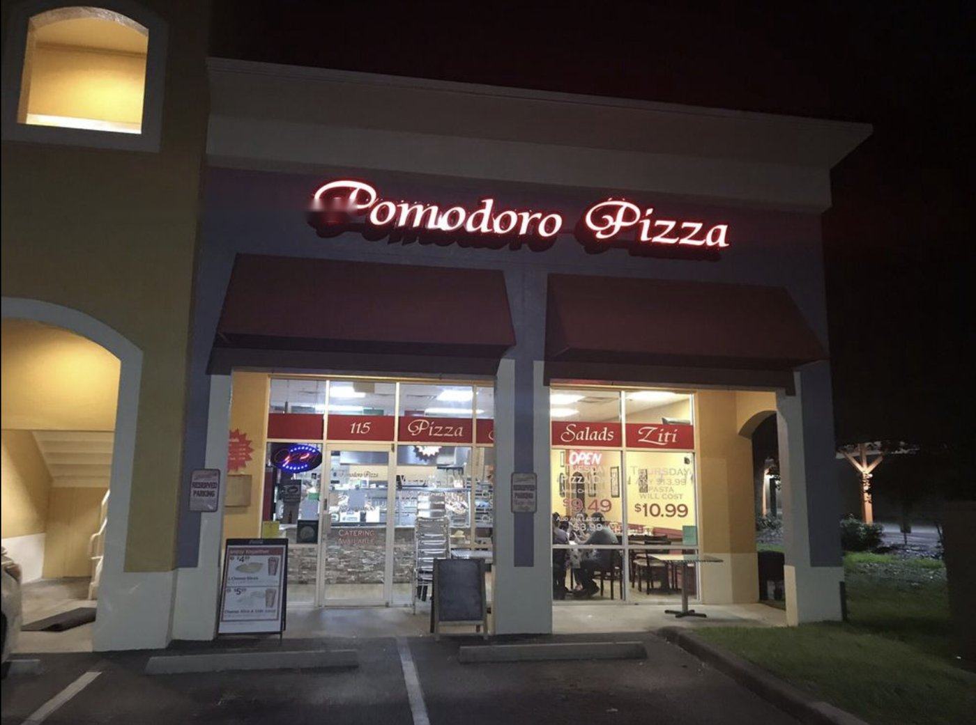 Pomodoro Pizza & More storefront lit up at night in Brandon, Florida